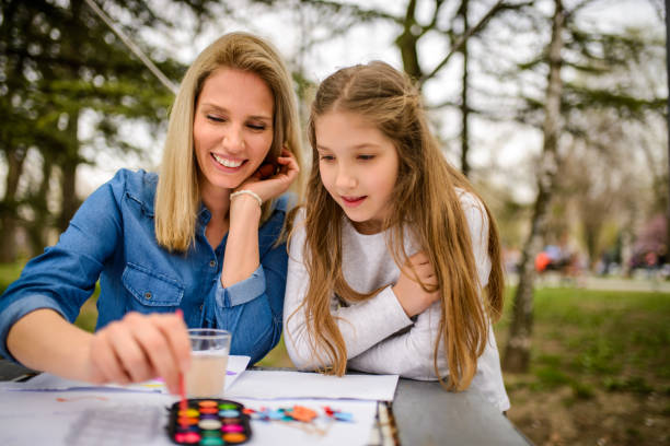 istock Mother and daughter painting. 1022819724