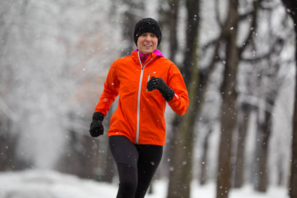 istock medium shot 40 years old woman jogging in winter snowfall 1022820094