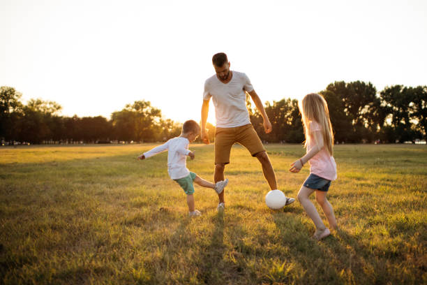 juego de futbol familiar - ball horizontal outdoors childhood fotografías e imágenes de stock
