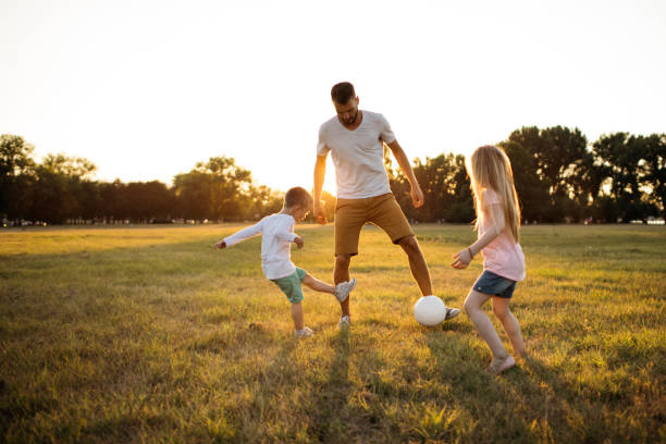 gioco di calcio per famiglie - ball horizontal outdoors childhood foto e immagini stock