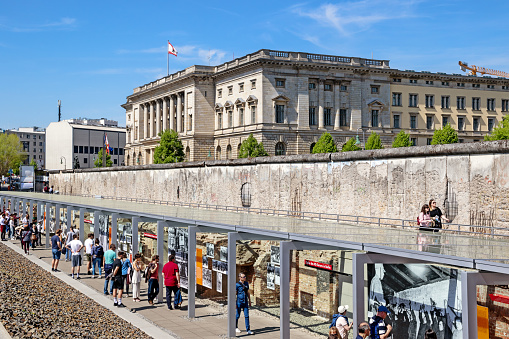 BERLIN - APRIL 28, 2018: Tourists walking past a part of the Berlin Wall at the Topography of Terror Documentation Center.