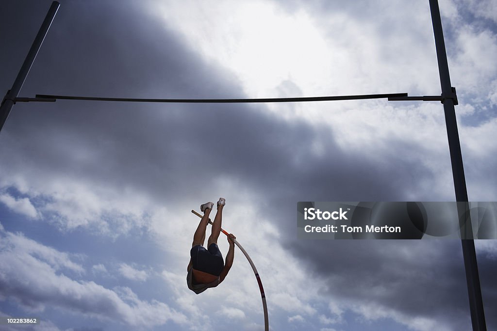 Saltatrice con l'asta in mid-air - Foto stock royalty-free di Salto con l'asta