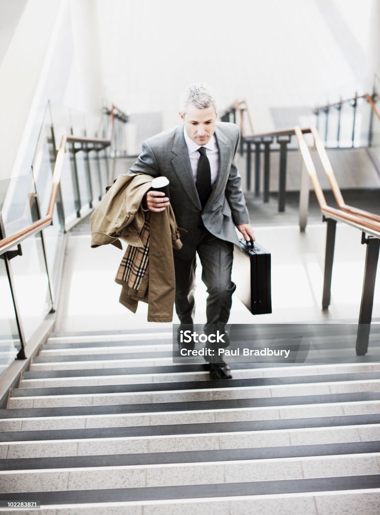 Hombre de negocios caminando hasta las escaleras en la estación de tren - Foto de stock de Maletín libre de derechos