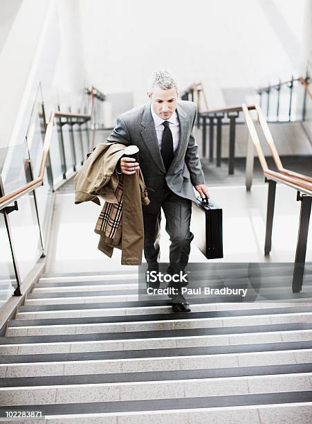 Hombre De Negocios Caminando Hasta Las Escaleras En La Estación De Tren Foto de stock y más banco de imágenes de Maletín