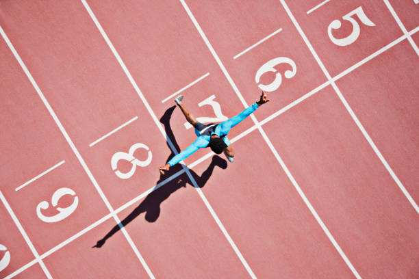runner crossing finishing line on track - garis finish potret stok, foto, & gambar bebas royalti