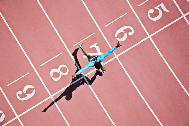 Photo of Runner crossing finishing line on track