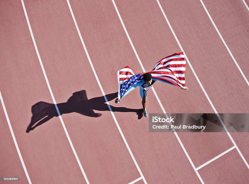 Runner celebrating on track with American flag  African Ethnicity Stock Photo