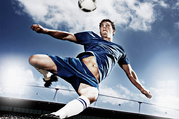 giocatore di calcio calciare pallone da calcio - sporting position vitality blurred motion strength foto e immagini stock