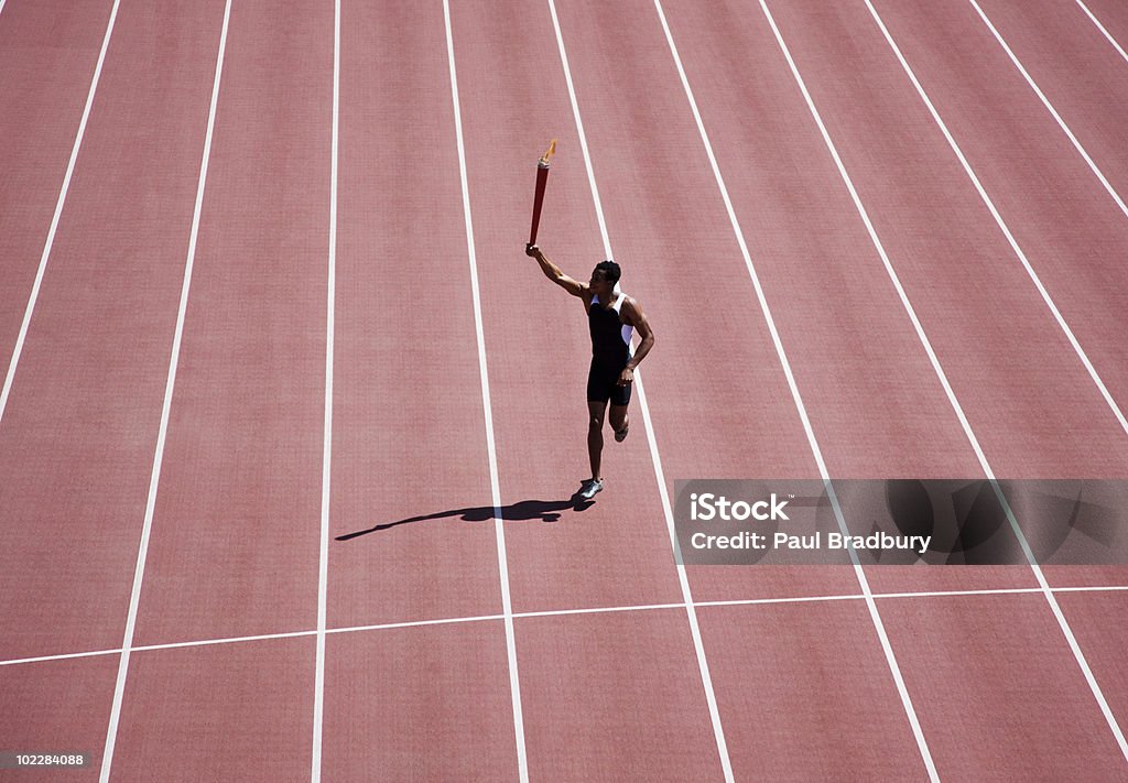 Runner running with torch on track  Flaming Torch Stock Photo