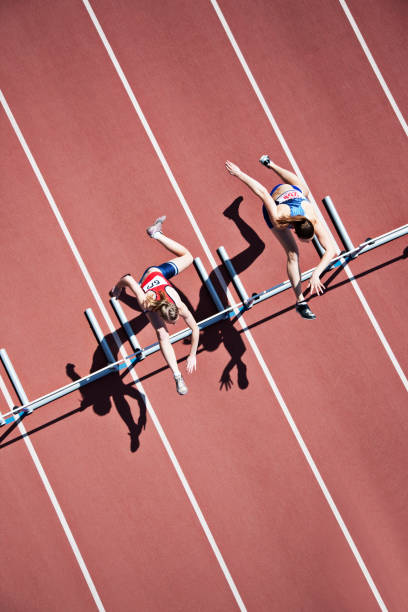 saut sur la piste de course de haies - hurdling photos et images de collection