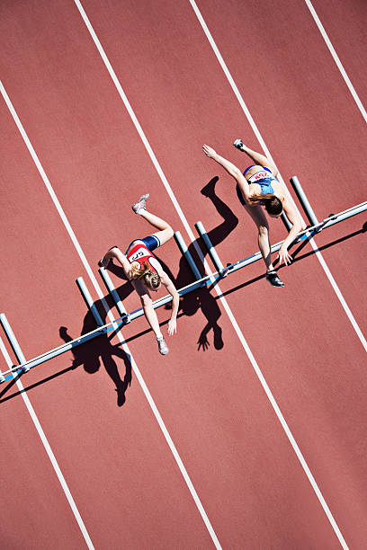 Runners jumping hurdles on track  hurdle stock pictures, royalty-free photos & images