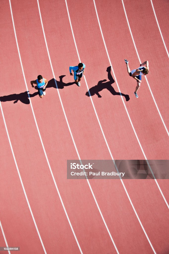 Les coureurs en compétition sur la piste - Photo de Couloir d'athlétisme libre de droits