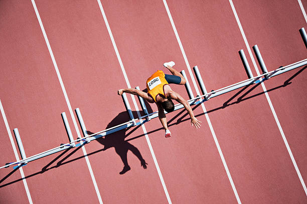 salto obstáculos on track runner - mens track fotos fotografías e imágenes de stock