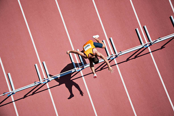 corridore saltando gli ostacoli sulla pista - atleta di atletica leggera foto e immagini stock