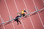 istock Runner jumping hurdles on track 102284192