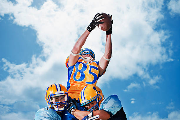 Football player catching football  wide receiver athlete stock pictures, royalty-free photos & images