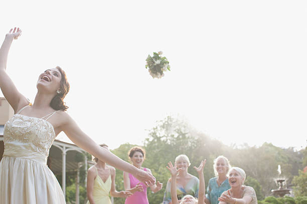 novia tirando bouquet en una recepción de bodas - flower toss fotografías e imágenes de stock