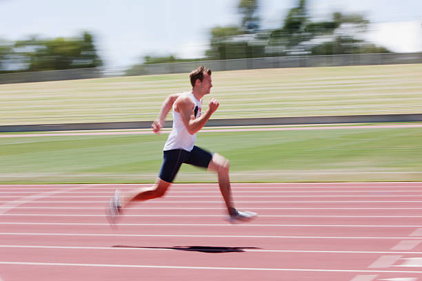 corredor correndo na pista - running sprinting blurred motion men - fotografias e filmes do acervo