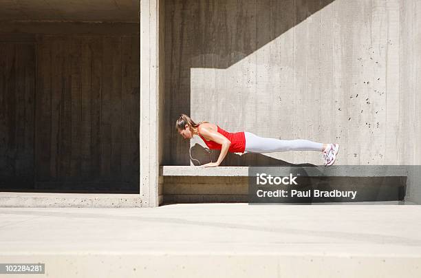 Mujer Haciendo Flexiones Sobre Cemento De Banco Foto de stock y más banco de imágenes de Flexiones - Flexiones, Mujeres, Una sola mujer