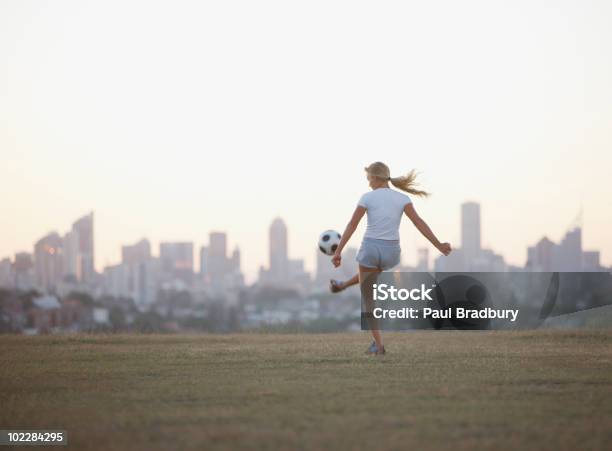 Photo libre de droit de Femme Frappe Ballon De Football Dans Le Parc Urbain banque d'images et plus d'images libres de droit de Football