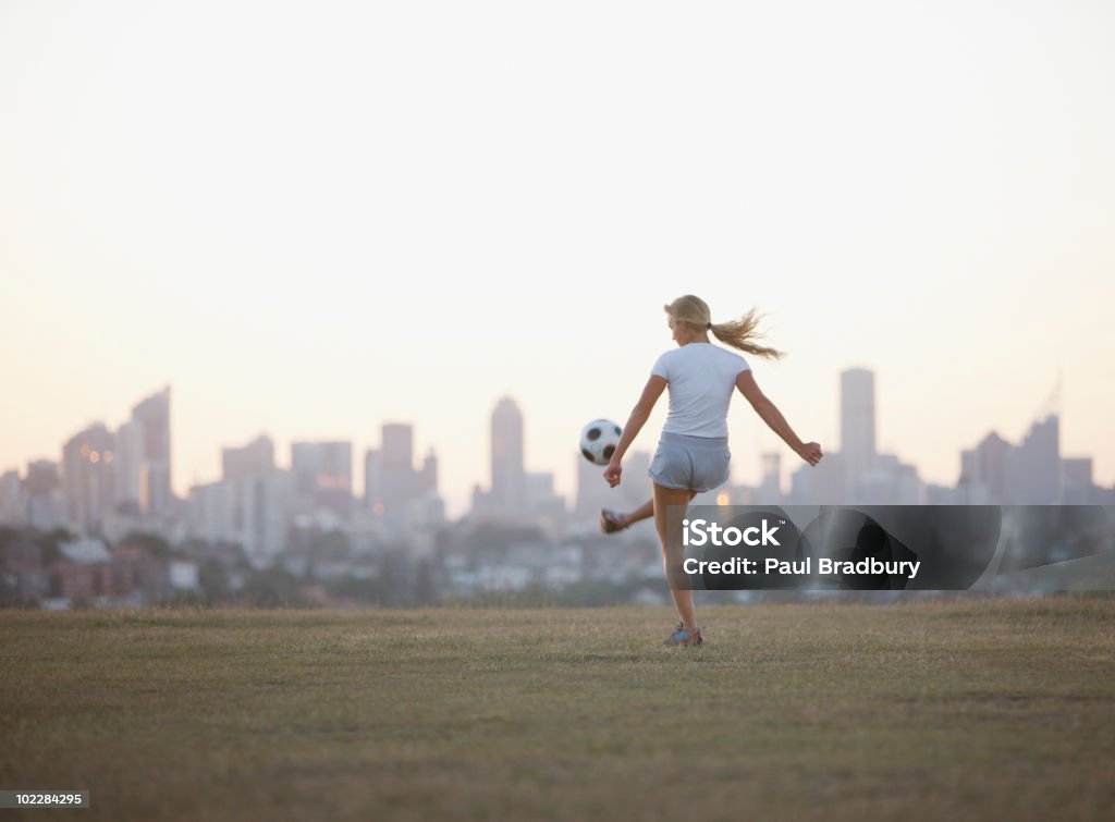 Donna calcio calcio palla nel parco urbano - Foto stock royalty-free di Calcio - Sport