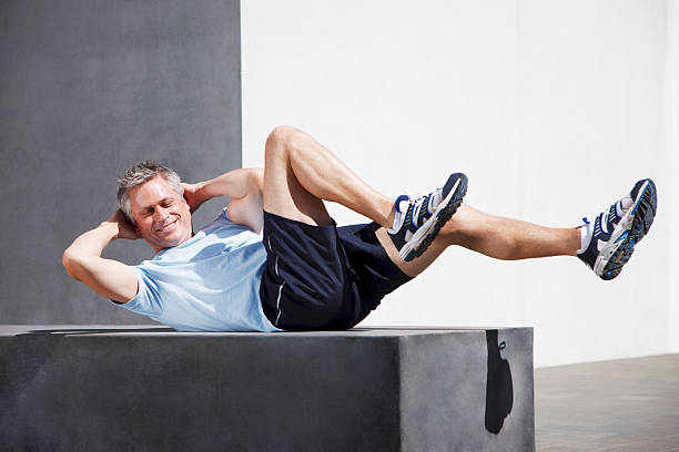 Man doing sit-ups in urban setting  sit ups stock pictures, royalty-free photos & images