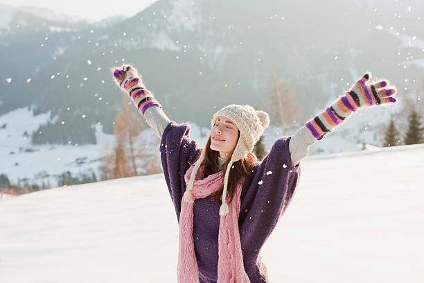 mulher com mãos estendidas em neve - scarf women hat warm clothing - fotografias e filmes do acervo