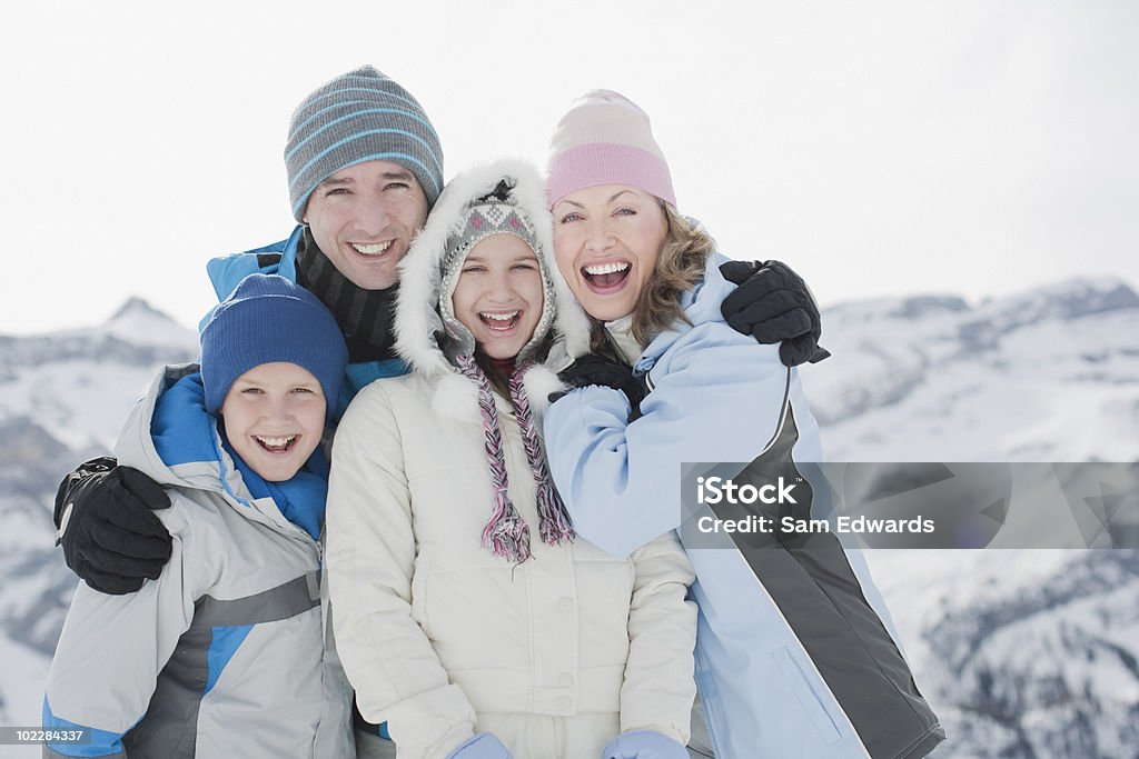 Famiglia abbracciare all'aperto nella neve - Foto stock royalty-free di Inverno