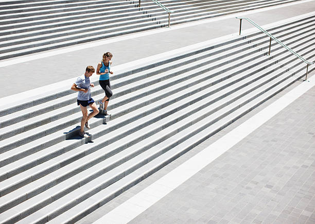 coureurs courir des escaliers - run down photos et images de collection