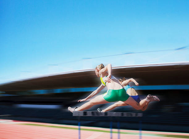 бегунов перепрыгивая через препятствия - hurdle hurdling track event women стоковые фото и изображения