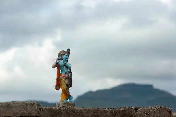 Krishna Idol with cloudy sky background