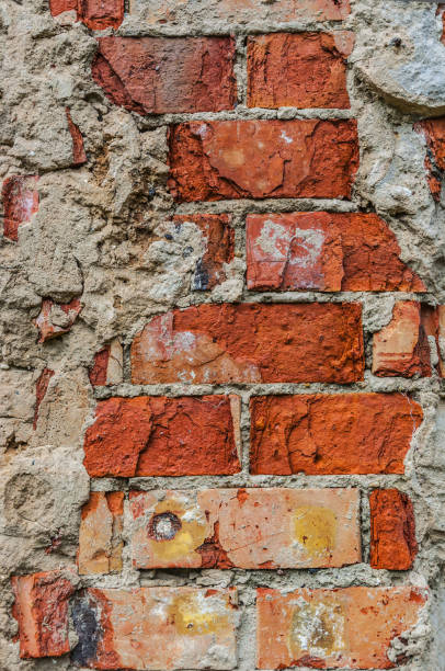 Red brick crumbled off wall wallpaper background backdrop stock photo