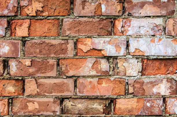 Red brick crumbled off wall wallpaper background backdrop stock photo