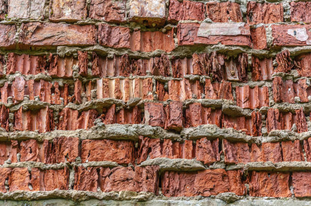 Red brick crumbled off wall wallpaper background backdrop stock photo