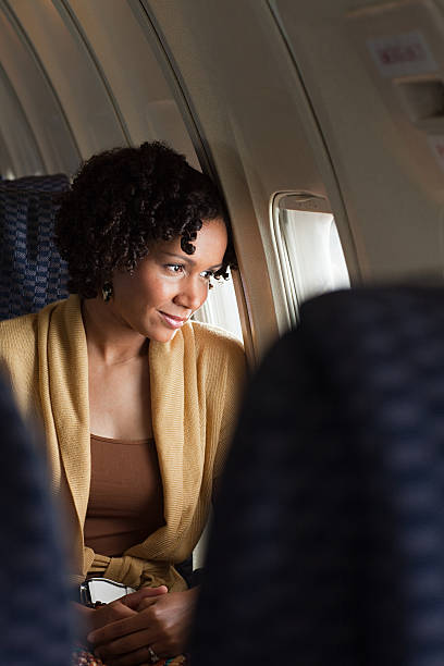 avión de pasajeros mujer mirando a través de la ventana - airplane window indoors looking through window fotografías e imágenes de stock