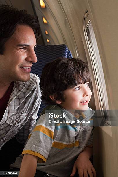 Padre E Figlio In Aereo - Fotografie stock e altre immagini di Aeroplano - Aeroplano, Viaggio, Guardare fuori dalla finestra