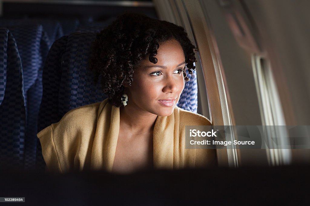 Femmina aereo passeggeri che guarda fuori dalla finestra - Foto stock royalty-free di Aeroplano