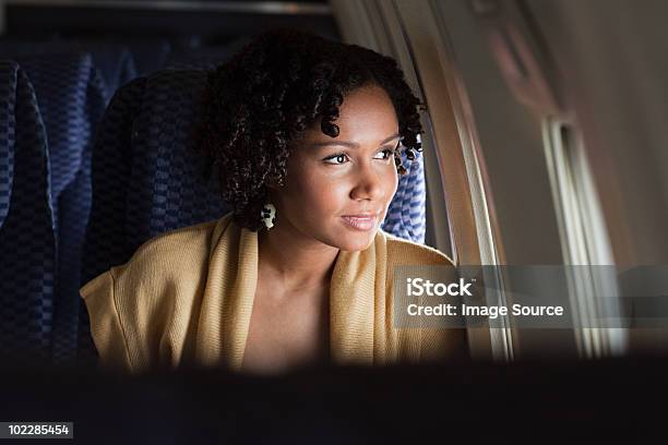 Female Airplane Passenger Looking Out Of Window Stock Photo - Download Image Now - Airplane, Women, One Woman Only