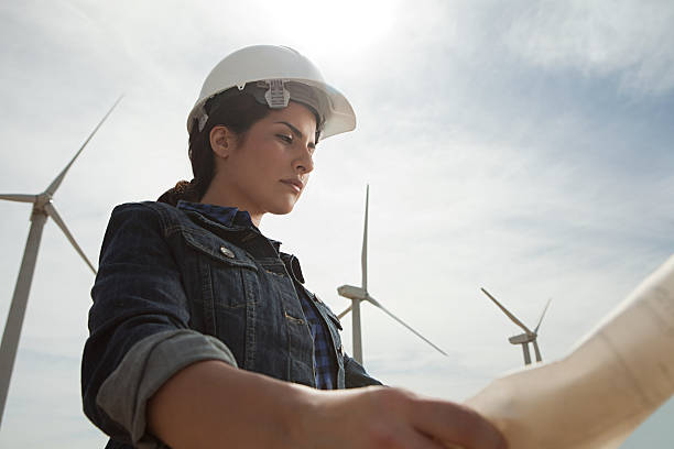 female engineer at wind farm with plans - wind energy industry 뉴스 사진 이미지