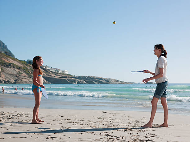 Mother and daughter playing paddleball on beach  paddle ball stock pictures, royalty-free photos & images