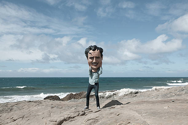 hombre joven con cabeza grande minimizar cara - california coastline beach cliff fotografías e imágenes de stock