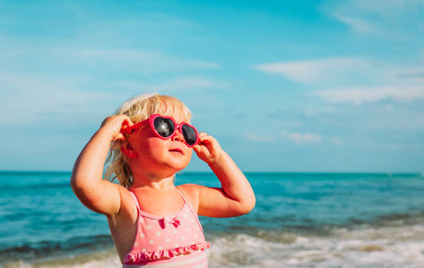 istock cute little girl with sunglasses on beach 1022864376