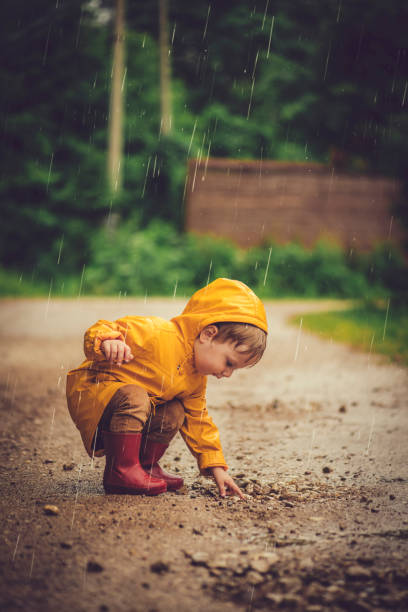Cute toddler outdoors under rain