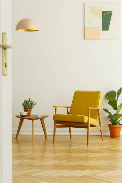 poltrona gialla e tavolino con tazza e pianta su parquet a spina di pesce in un interno del soggiorno. foto reale - style armchair contemporary furniture foto e immagini stock