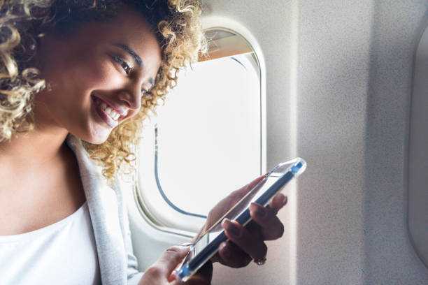 istock Smiling airplane passenger uses smartphone during flight 1022880164