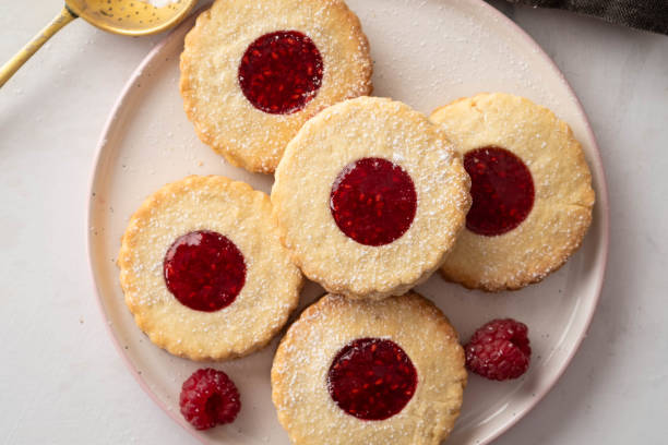 istock Christmas cookies. Linzer cookies with raspberry jam on white table background. Traditional Austrian biscuits filled. Top view and copy space 1022880474