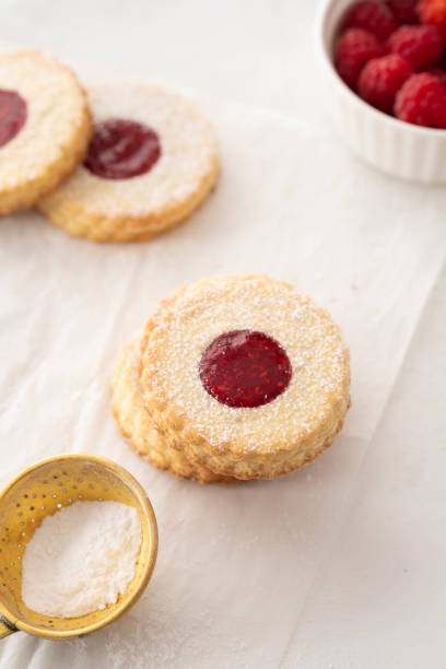 istock Christmas cookies. Linzer cookies with raspberry jam on white table background. Traditional Austrian biscuits filled. Top view and copy space 1022880518