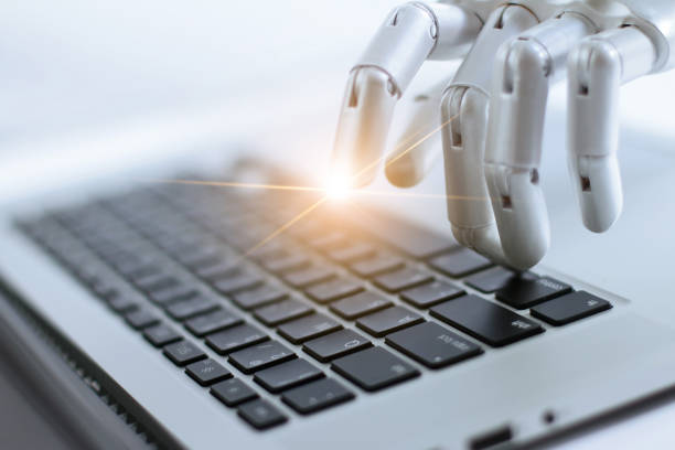istock Robot finger point and working to laptop keyboard button, AI, Artificial Intelligence, Robotic hand on digital gray background. Futuristic technology concept. 1022887864