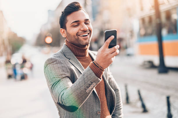 istock Smiling man with a cell phone on the street 1022889218