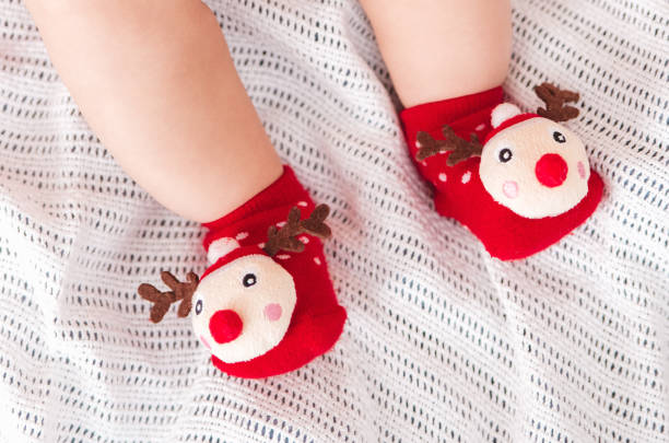 les pieds de bébé dans funny chaussettes de noël. joyeuses fêtes et bonne année - christmas child baby surprise photos et images de collection
